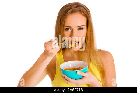 Donna bionda mangiare cereali dalla ciotola con cucchiaio. Una sana colazione per weightloss. Foto Stock