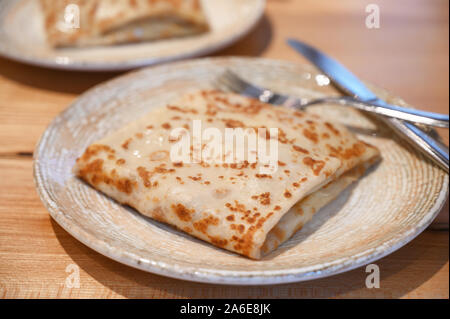 Tradizionale piatto russo blinis con cavolo ripieno su una piastra Foto Stock