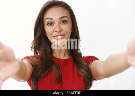 Close-up shot gara femminile cute giovane donna felice, sorridente silly tendere le mani avanti come tenere la fotocamera, tenendo selfie, video chiamata tramite Foto Stock