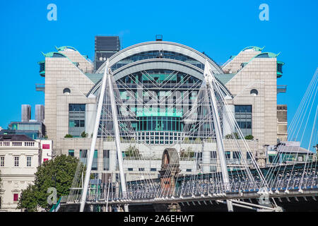 Il Golden Jubilee Bridges, una passerella pedonale, con la sponda del fiume di Charing Cross Station in background in Londra Foto Stock