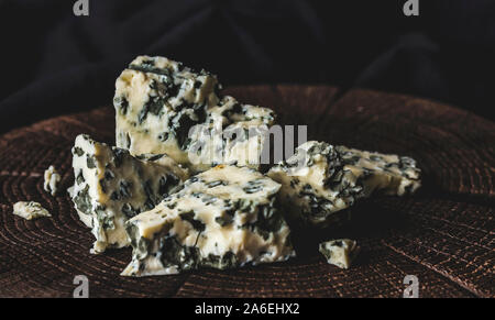 Danese formaggio blu su nero lo sfondo di legno, con spazio di copia Foto Stock
