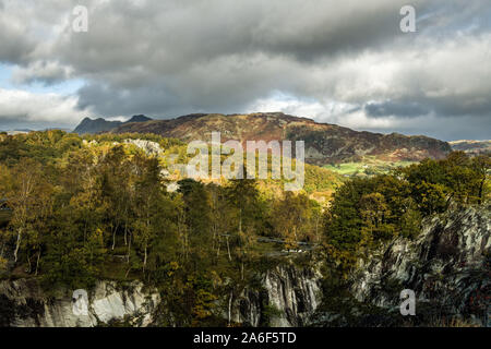 Guardando oltre Hodge Close Quarry Lip al Langdale Pikes in lontananza, nel Lake District National Park, Cumbria. Un bellissimo paesaggio. Foto Stock