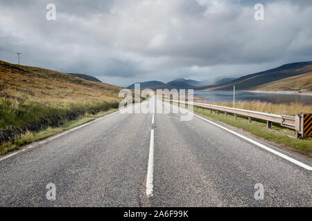 Lungo tratto rettilineo di vuoto strada che conduce alla montagna in Sutherland nelle Highlands scozzesi Foto Stock