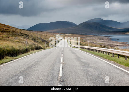 Lungo tratto rettilineo di vuoto strada che conduce alla montagna in Sutherland nelle Highlands scozzesi Foto Stock