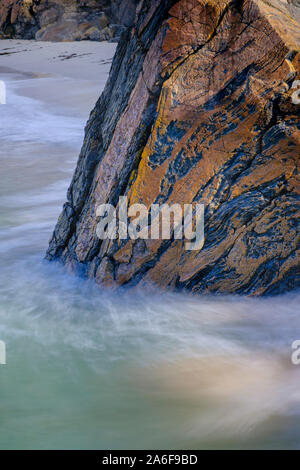 Spiaggia remota sulla riva del: Achmelvich Bay in Assynt, Sutherland nel nord ovest di Highlands scozzesi nota massiccia Lewisian gneiss boulder in primo piano Foto Stock