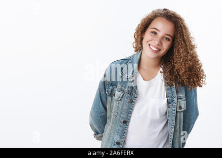 Carino carismatico felice modesto chubby giovani curly-ragazza dai capelli tenere mani dietro piacevolmente sorridere timido sorriso di gara testa tiltante silly vuoi aiutare Foto Stock