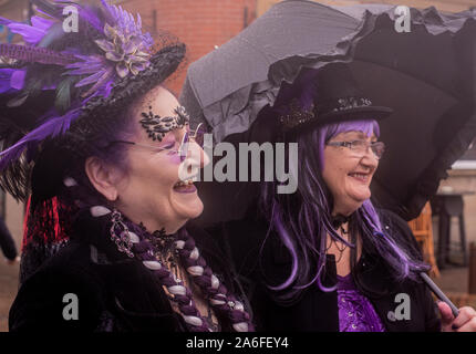 Due amici allegra nei tradizionali costumi di Goth, Whitby Goth Festival Weekend, Whitby, North Yorkshire, Regno Unito, 26 Ottobre 2019 Foto Stock