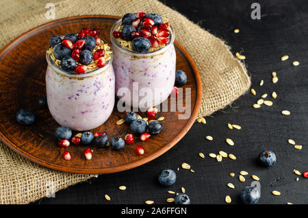 Lo yogurt greco con frutti di bosco freschi e avena. Uno stile di vita sano concetto. Foto Stock