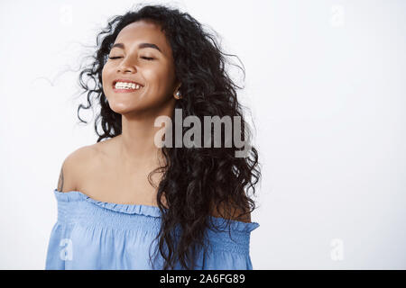 Close-up gratuito e alleviato felice attraente, incoraggiati african american curly-donna dai capelli con tatuaggi in blu camicetta, inalare aria fresca chiudere gli occhi Foto Stock