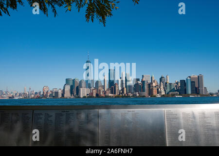 Ellis Island Museo Nazionale della parete di immigrazione di onore con New York skyline della città in background, NYC, STATI UNITI D'AMERICA Foto Stock