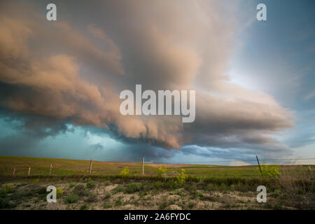 Il ripiano nuvola di una violenta tempesta è splendidamente illuminato dalla luce del sole al tramonto in questo drammatico meteo scena. Foto Stock