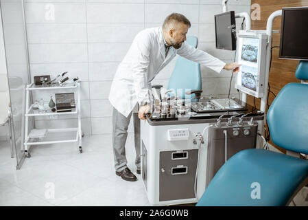 Senior otolaryngologist lavorando in ufficio ENT, esame CT immagine della testa del paziente cavità Foto Stock