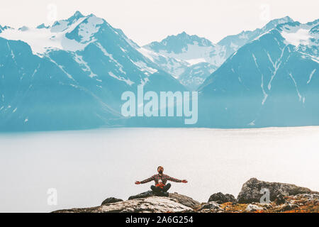 Padre con baby meditando in montagna rilassante yoga outdoor sano stile di vita della famiglia vacanze viaggi in armonia con il concetto di natura Foto Stock