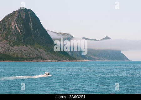 Husoy isola in Norvegia montagne e barca in mare paesaggio percorsi di viaggio paesaggi scandinavi Senja isole Foto Stock