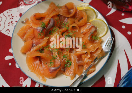 Salate e salmone affumicato in stile scandinavo e servita affettata con qualche aneto e limone. Minaccia tradizionale nella tavola del Natale come antipasto. Foto Stock