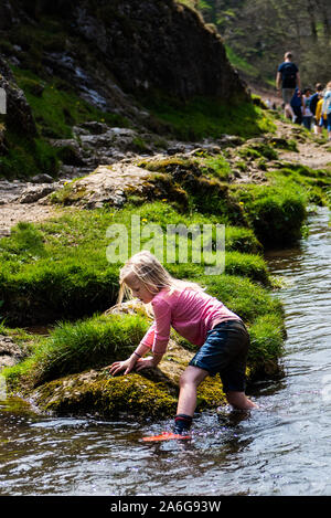 Una graziosa bambina pagaiando dal famoso Dovedale pietre miliari nel Derbyshire Parco Nazionale di Peak District Foto Stock