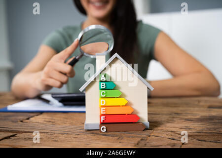 Casa con efficienza energetica tasso di fronte ai mediatori che lavorano in ufficio mentre utilizzando la calcolatrice Foto Stock
