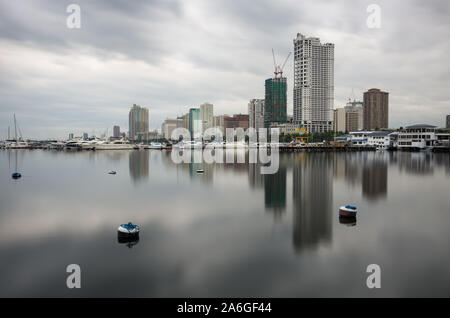 La lunga esposizione dello skyline di Manila Bay è stata fatta al mattino nuvoloso. Foto Stock