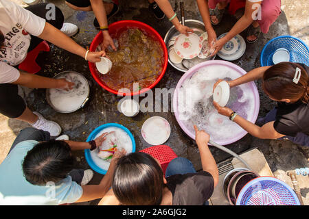 Le donne lavare le loro stoviglie, bacchette e posate all'interno delle antiche mura della città di Zhaoqing in Cina. Lavaggio comunale up è un passatempo molto diffuso Foto Stock