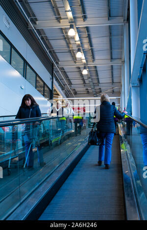La gente ride con la scala mobile al grande supermercato Sainsbury's, shop, supermercato a Newcastle under Lyme Foto Stock