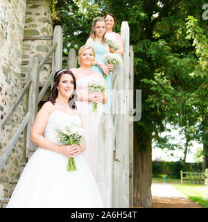 La bella sposa e le sue damigelle hanno in posa per alcune foto dopo la grande cerimonia di nozze Foto Stock