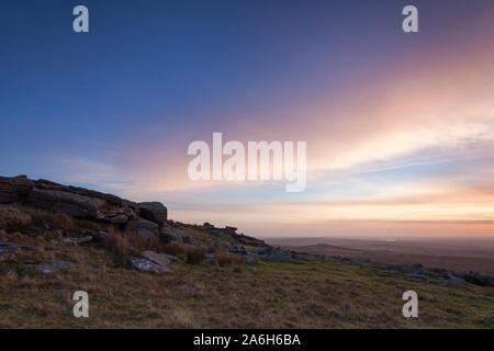 Cielo di tramonto su rocce di granito a poco pinzare Tor sul Parco Nazionale di Dartmoor Foto Stock