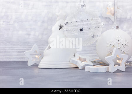 Anno nuovo tempo concetto di decorazione. Albero di natale palle di vetro, luci a forma di stella e il candelabro decorativo bianco su sfondo di legno Foto Stock