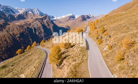 Strada per il Gavia mountain pass in Italia. Incredibile vista aerea della montagna si piega creando splendide forme. Tempo di caduta. Colori caldi Foto Stock