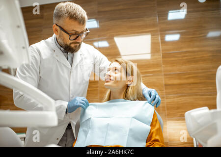 Preparazione del dentista per un trattamento medico, il medico e il paziente a sorridere a ogni altra sensazione di fiducia Foto Stock