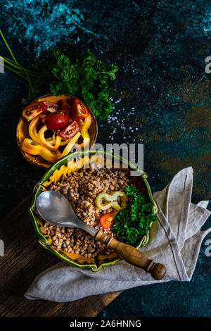 Dieta cheto concetto con bolliti di semi di grano saraceno e verdure in una ciotola rustico in pietra con sfondo copyspace Foto Stock