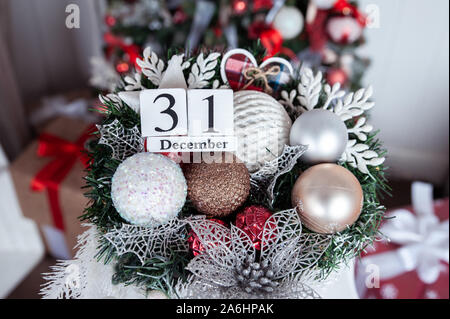 Calendario di legno con sullo sfondo di un albero di Natale con una data di Dicembre 31, un simbolo del nuovo anno Foto Stock