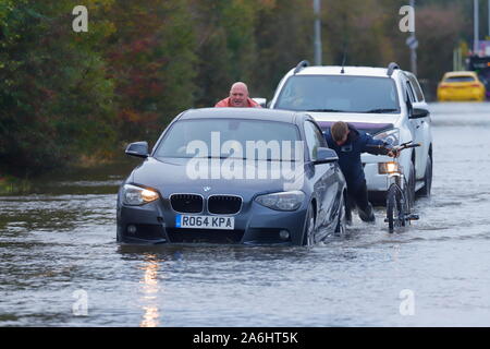 Buoni Samaritani spingere una vettura fuori acqua di inondazione dopo diventando arenati su Barnsdale Road a Castleford. Foto Stock