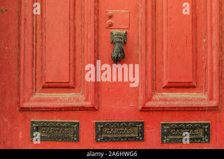 Una vecchia porta rossa con su una strada nel centro di Porto. Portogallo Foto Stock