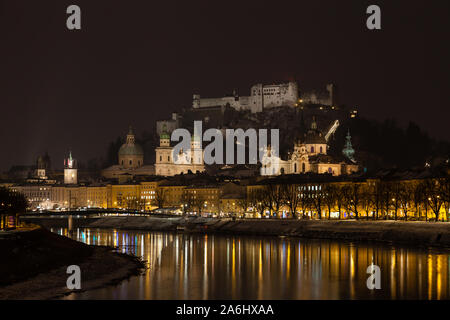 Un tempo di notte vista attraverso il Fiume Salzach a Salisburgo, Austria. In fondo è la Fortezza di Hohensalzburg. Foto Stock