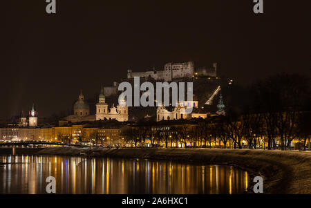 Un tempo di notte vista attraverso il Fiume Salzach a Salisburgo, Austria. In fondo è la Fortezza di Hohensalzburg. Foto Stock