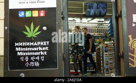 Shop cannabis canapa medica, vende anche prodotti di semi, addicted persone fanno uso di sostanze stupefacenti, Vetrina negozio display con simboli di cannabis, le persone stanno entrando Foto Stock