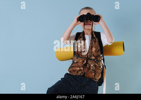 Little Boy giocando escursionista a casa. Guardando attraverso il binocolo. Close up. Foto Stock