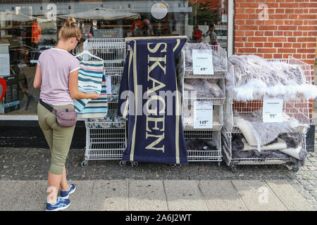Donna cercando di acquistare una coperta e un asciugamano con una iscrizione di Skagen è visto in Skagen, Danimarca il 28 luglio 2019 Skagen Danimarca è la città più settentrionale, sulla costa orientale di Skagen Odde penisola nel lontano nord dello Jutland. © Michal Fludra / Alamy Live News Foto Stock