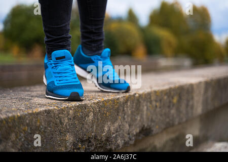Sneakers blu su una donna gambe. Al di fuori di allenamento nelle scarpe da running concept Foto Stock