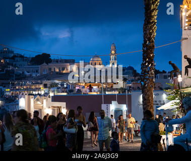 Fira, Grecia - 14 Luglio 2019: notte tempo colpo di turisti a piedi lungo la scogliera di strada Ipapantis Foto Stock