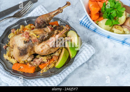 Pot-fagiano arrosto in sidro con pancetta e verdure Foto Stock