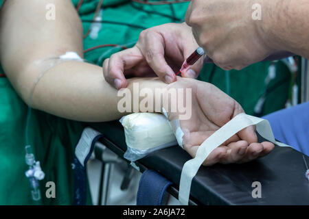 Medico tenendo campione di sangue dal paziente in sala operatoria. disegno di sangue campione di sangue per il test della salute. Foto Stock