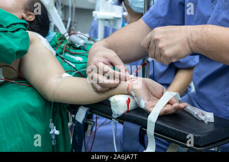 Medico tenendo campione di sangue dal paziente in sala operatoria. disegno di sangue campione di sangue per il test della salute. Foto Stock