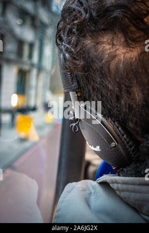Retro della testa di uomo che indossano le cuffie al piano superiore di un bus Foto Stock