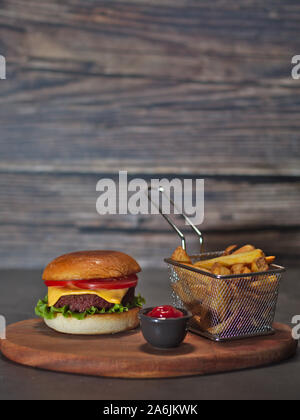 Vegan impianto basato hamburger con patatine fritte e ketchup servita su rustiche vassoio in legno Foto Stock