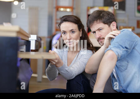 L uomo e la donna la scelta di materiale per mobili da cucina in salone Foto Stock