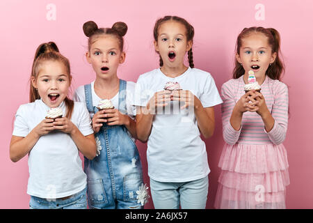 Incantevole bambini stupendi hanno preparato Deliziose tortine, isolato sfondo rosa, studio shot, parte il tempo, tempo di festa Foto Stock