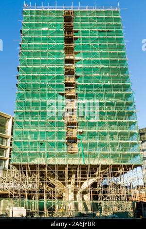 Alta torre di blocco sotto costruzione e coperto con detriti di impalcatura per la sicurezza sulla rete di un edificio sito, Nottingham, Inghilterra, Regno Unito Foto Stock