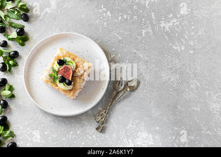 Pavlova su un biscotto con una delicata crema di cagliata, fichi e uva. Una nuova variante del classico dolce Australiano. Foto Stock