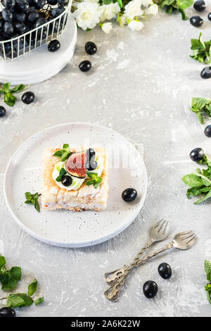 Pavlova su un biscotto con una delicata crema di cagliata, fichi e uva. Una nuova variante del classico dolce Australiano. Foto Stock